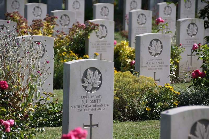 Headstones with carved Canadian maple leaf in Beny-sur-Mer Canadian War Cemetery