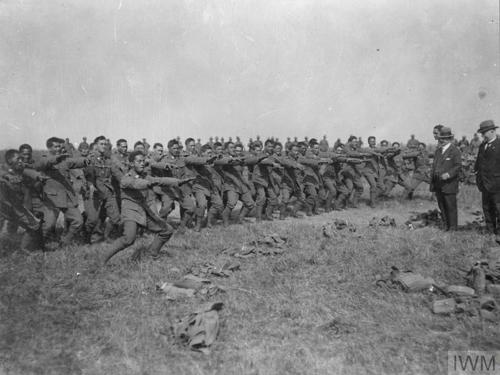 A black and white photo showing New Zealand Maori troops performing a haka war dance to officers and politicians.