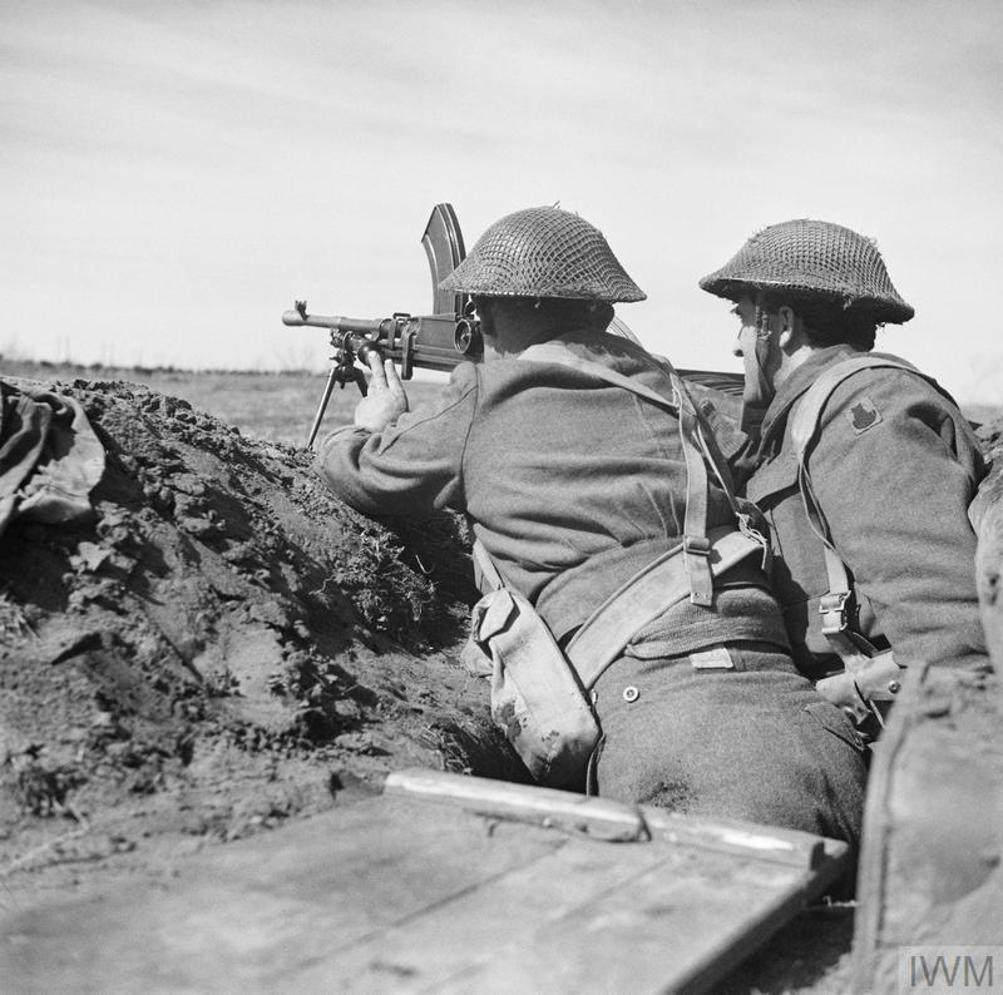 Two British soldiers scan the horizon from a trench.