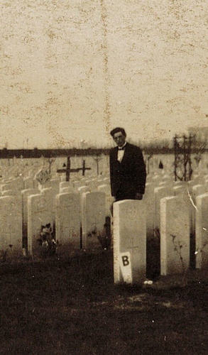 Man standing amongst headstones in cemetery