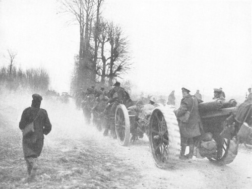 British soldiers pull a wheeled artillery gun along a country road during the retreat on the Somme in 1918.