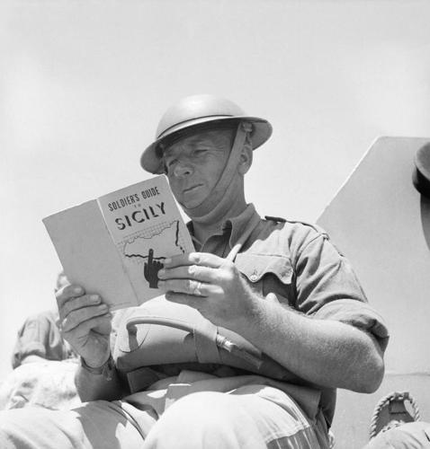 A British soldier reads a guide to Sicily prior to the 1943 invasion.