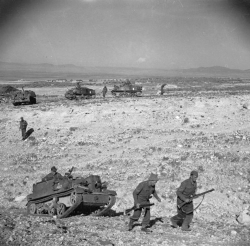 British troops escort universal carriers through the desert.