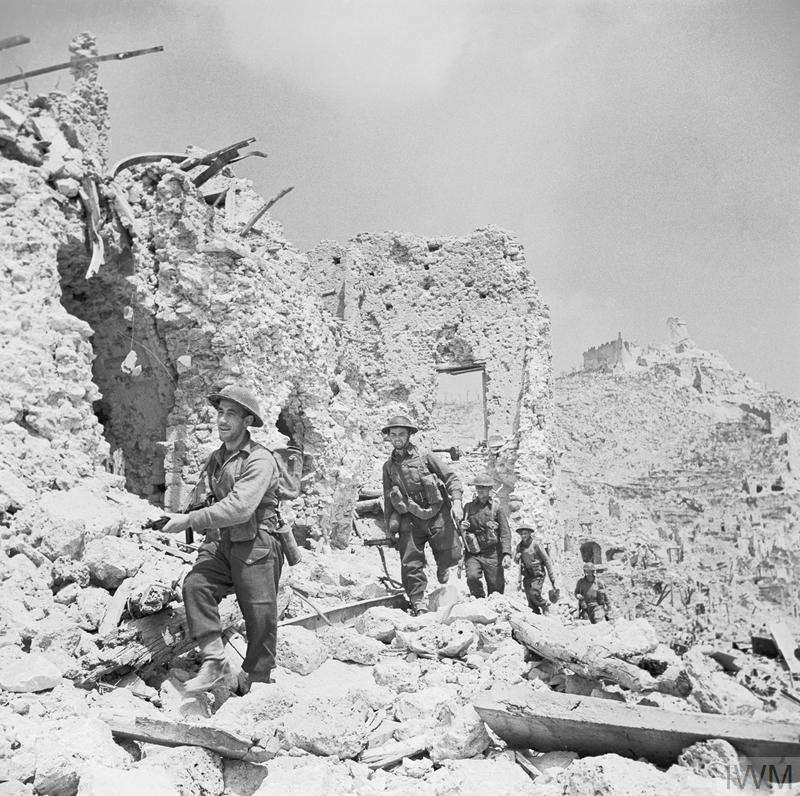 British soldiers navigate the heavily rubble-strewn landscape at Monte Cassino.