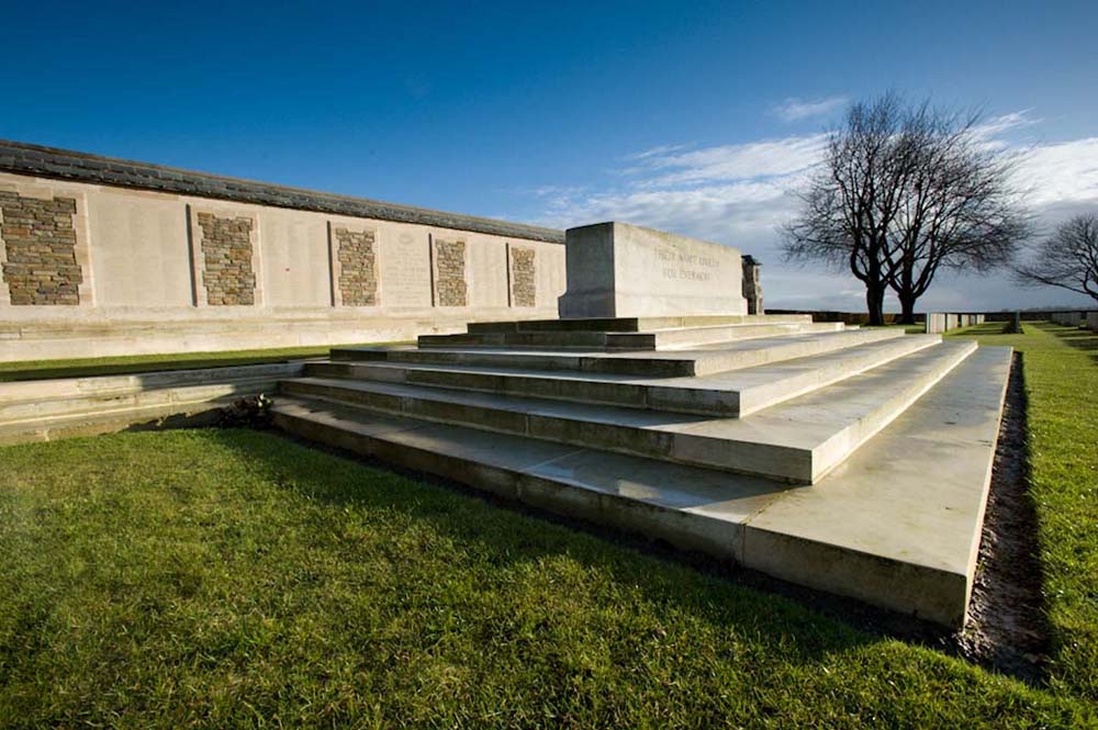 The Caterpillar Valley (New Zealand) Memorial with the Stone of Remembrance with a blue sky and green grass.