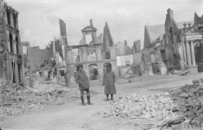 Two British soldiers standing amidst the devastation of Ypres town centre during World War One.