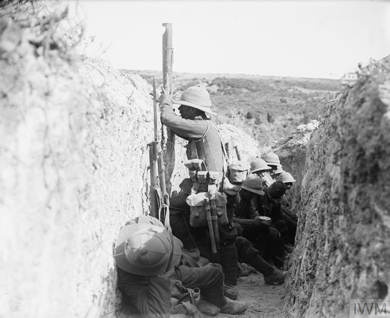 A British soldier wearing a pith helmet uses a periscope to peak over the top of a trench in Gallipoli 1915.