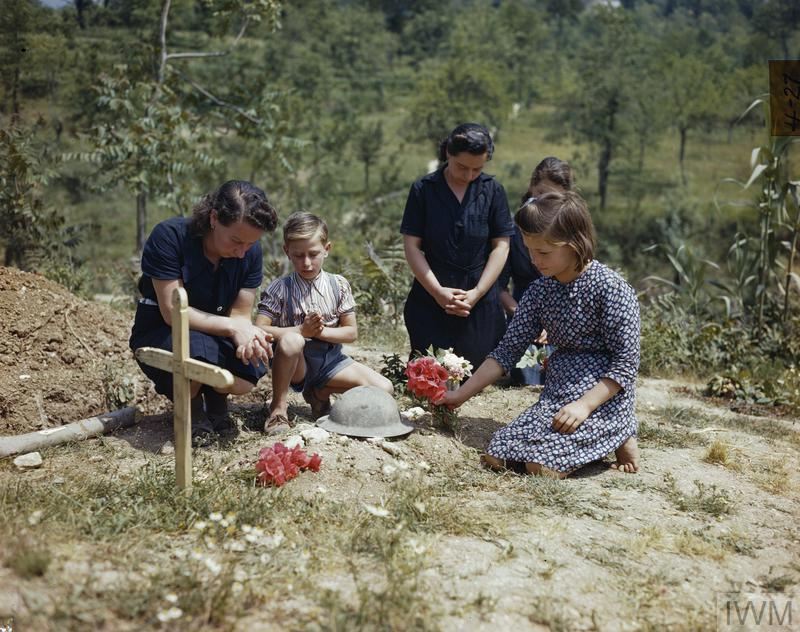 Civilians lay flowers on the grave of an unknown British soldier.