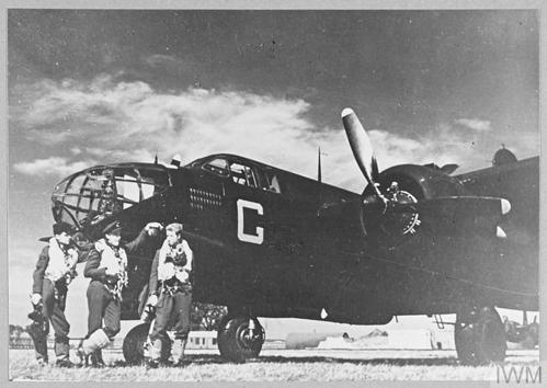 WW2 Era bomber aircrew stand in front of a Boston Bomber aircraft.