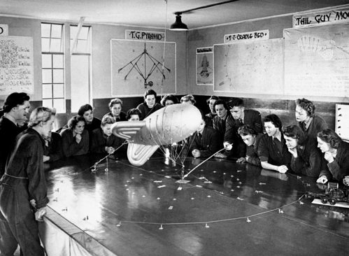 WAAFs studying a model of a barrage balloon in a classroom during the Second World War.