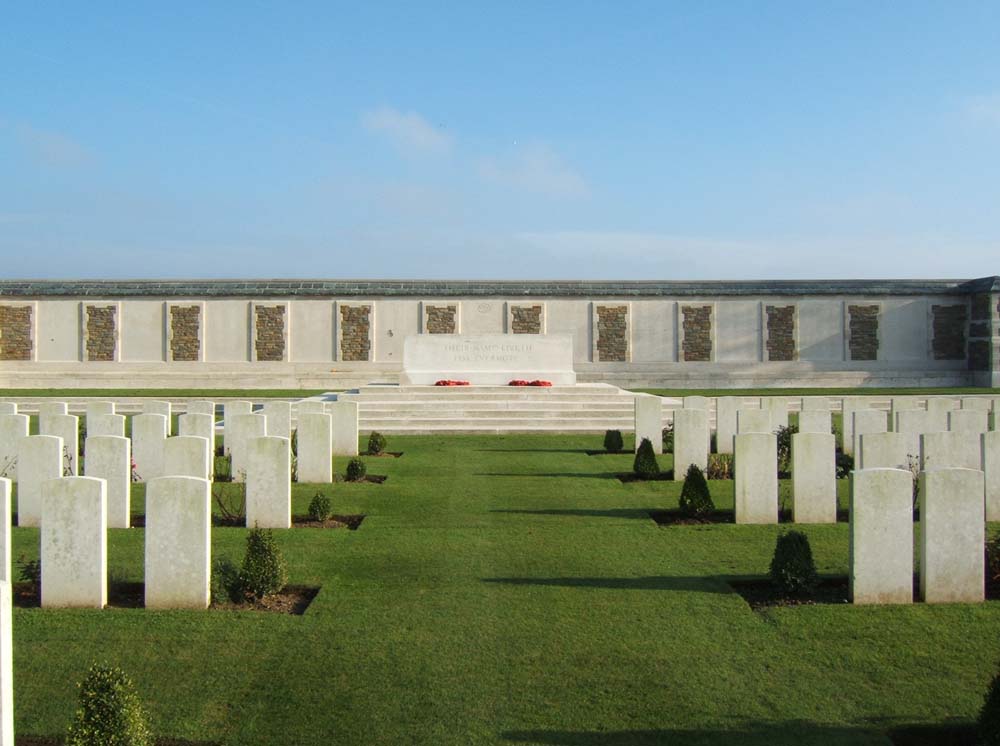 Long shot of the Caterpillar Valley (New Zealand) Memorial sitting ahead of multiple rows of war graves headstones.