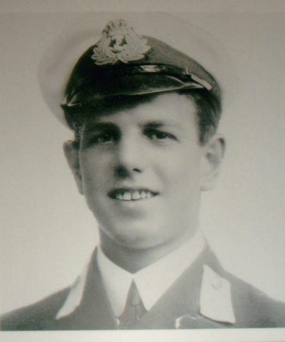 Ernest Cunningham poses in his naval uniform. He is wearing a peaked cap and a smart blazer.