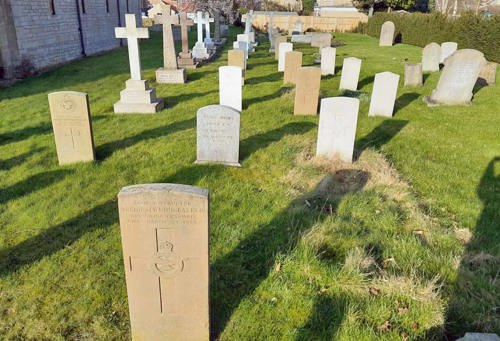 Cranwell St Andrew C of E Churchyard, showing different types of headstones & markers over military graves interspersed with civilian headstones. These include War Graves with private markers (crosses on the left), CWGC War Grave headstones as well as MOD Headstones.