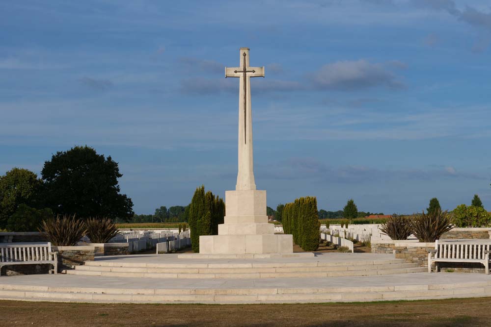 The Cross of Sacrifice standing atop a stepped stone plinth in Bedford House Cemetery.