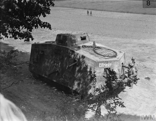 Black and white photograph of the German World War One tank "Elfriede" sitting under the shade of a tree after its capture at Villers-Bretonneux.